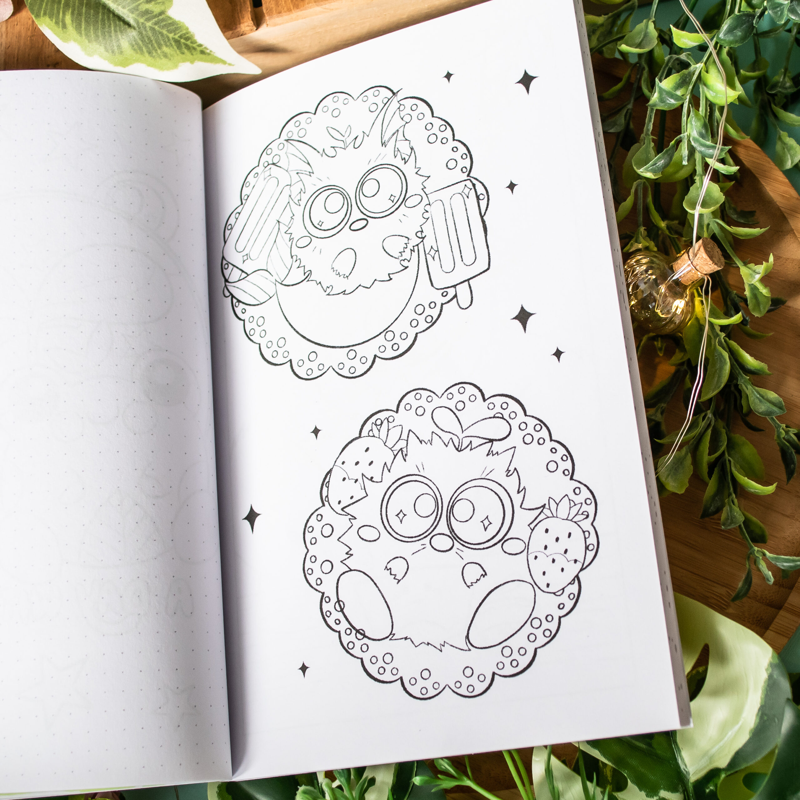Un livre de coloriage « Coloriages de Poussiérons », ouvert, présente deux pages illustrées de mignons petits animaux ronds encadrés par des bordures circulaires — l’un tenant des glaces à l’eau, l’autre des fraises —, entourés d’étoiles, de feuilles vertes et d’une ampoule.