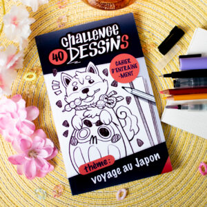 « Challenge 40 dessins : voyage au Japon » est un cahier de dessin dont la couverture représente un adorable chien shiba qui mâche une brochette de dango en s'appuyant sur un daruma. Le carnet est entouré de stylos, crayons de couleurs, de papiers, matériel créatif et de fleurs décoratives.