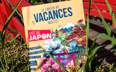Un livre d'activités en français intitulé « Guide de survie pour voyageur paumé au Japon » repose dans des buissons verts près d'un pont en bois rouge ; sa couverture colorée est ornée d'illustrations représentant des sites emblématiques japonais.